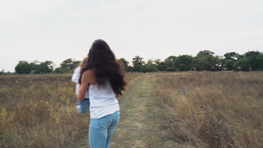 mother playing with her little daughter on the autumn field