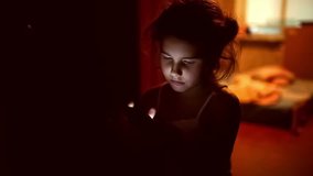 girl teen  looking smartphone game on Internet in corridor indoor yellow brown silhouette