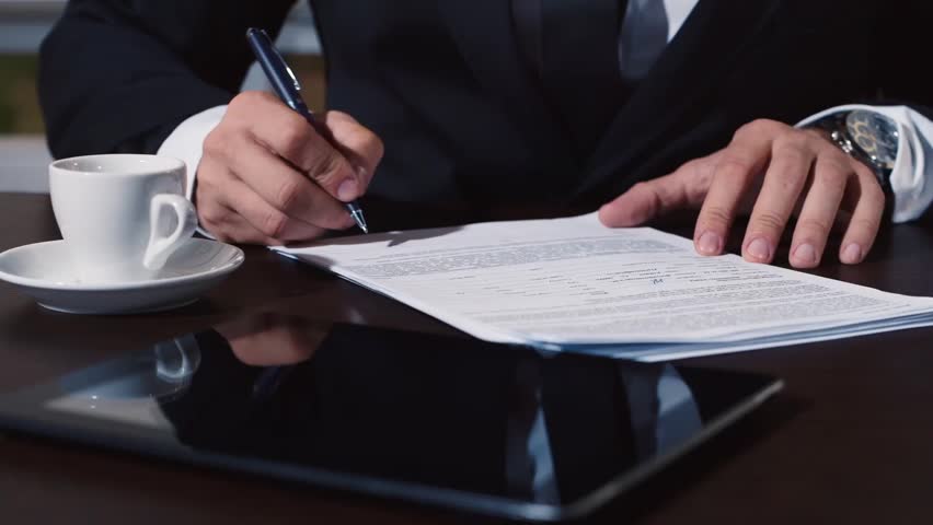 Man's hand in a business suit signs documents Royalty-Free Stock Footage #12411560