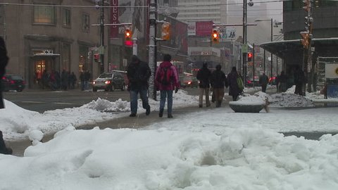 A busy downtown intersection in the middle of a snow storm.