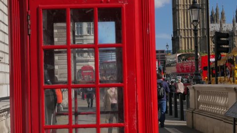 LONDON/ENGLAND SEPTEMBER 10TH 2015: Tilt up a red telephone box with Big Ben and the Elizabeth Tower in the background. Taken on a sunny September afternoon in 4K