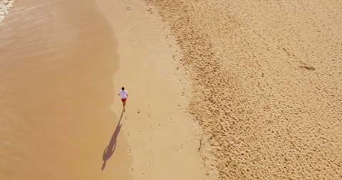 Aerial Shot of Young Man Running on Beach  Stock Video