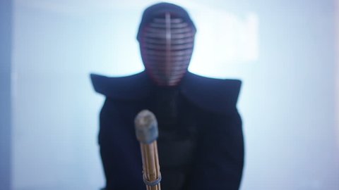 4K Portrait of a Japanese kendo fighter lowering his shinai towards the camera. Shot on RED Epic.
