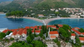 A helicopter flight over the island of Sveti Stefan in Montenegro. Aerial photography, video from a height, the height of bird flight. Flying over the sea, the coast and the Balkans