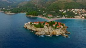 A helicopter flight over the island of Sveti Stefan in Montenegro. Aerial photography, video from a height, the height of bird flight. Flying over the sea, the coast and the Balkans