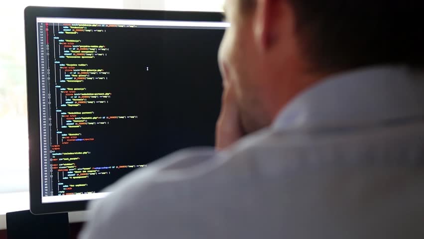 programmer from behind and programming code on computer monitor (programming code is my own property there is no possible trademark or copyright infringement) Royalty-Free Stock Footage #12448643