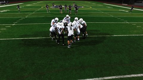 A football team in a huddle before a game, view from above