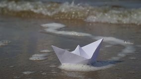 Paper boat floating on the river. Flips
