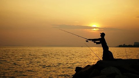 fisherman fishing, silhouette in sunset, Slow motion.