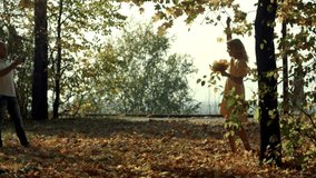 Young woman with autumn leaves in hand and fall yellow maple. Shot on BMCC RAW with high dynamic range. You can use it e.g in your video, documentalistic, reporting, family, music video, commercial