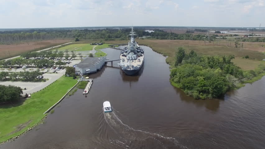 USS North Carolina historic memorial in Wilmington NC, USA. Aerial establishing shot flying behind the decommissioned battle ship. (2015)