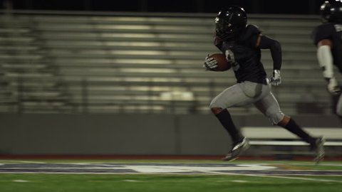 A football player runs past the defense and makes a touchdown, in slow motion : vidéo de stock
