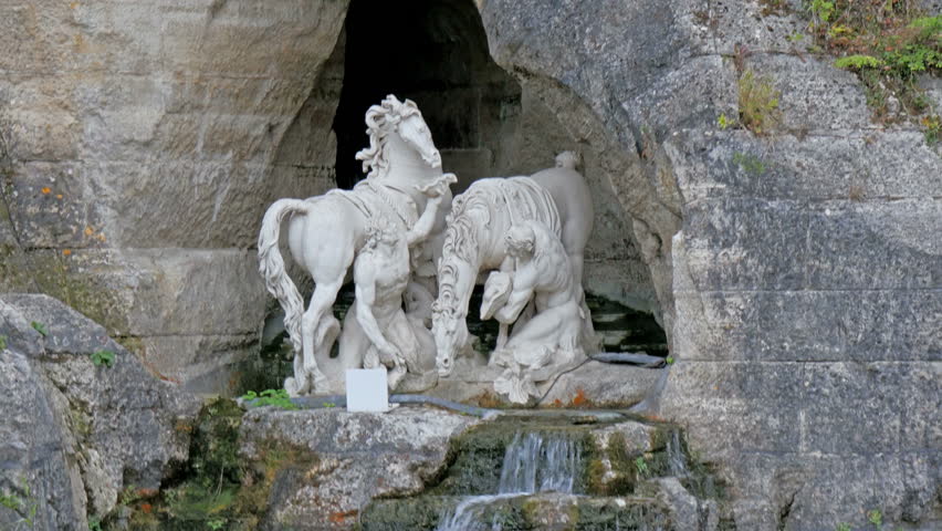 Horse statue on the rock fountain outside the castle. Water coming out from the small waterfalls with the statue