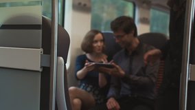 Man and Woman are Traveling in Train and using Tablet for Entertainment. Shot on RED Cinema Camera in 4K (UHD)