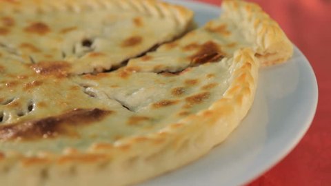 Ossetian pie is a traditional Caucasus cuisine, answer to ubiquitous pizza. These home baked large round pastries usually filled with meat, cheese, potatoes or greens.