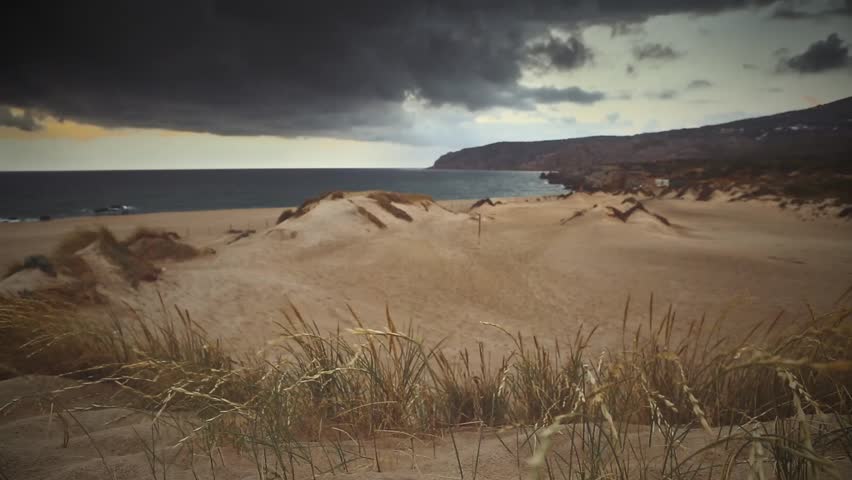 Cinemagraph Loop - Dark clouds over sand dunes on beach - motion photo