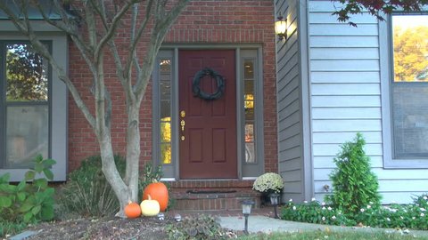 Establishing shot of the front door of a house; autumn / fall and in the daytime / morning or early evening.  This is part of a set of shots of the same house in all seasons of the year.
