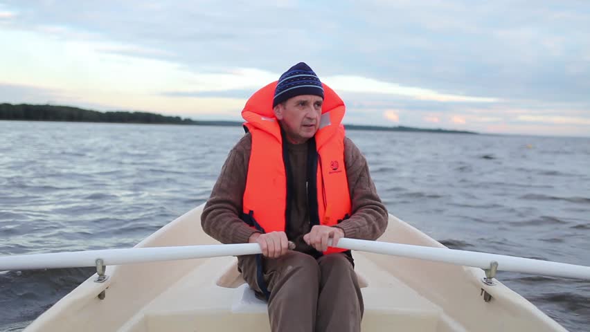 Man in a life jacket at the oars