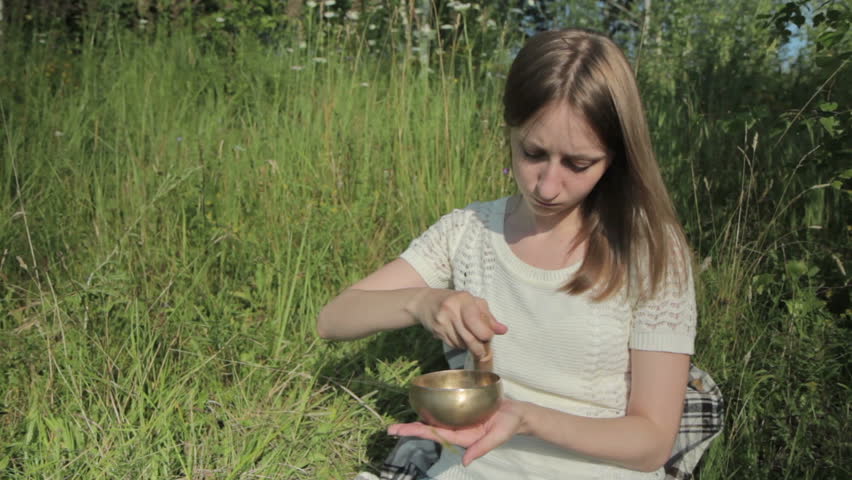 Young beautiful lady relaxing with nepal singing bowl