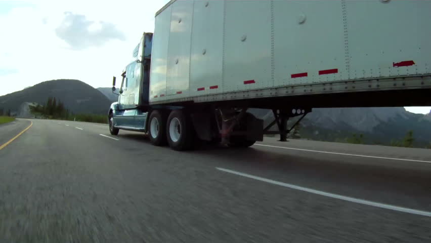 Vehicle pov shot of semi trailer truck traffic on highway