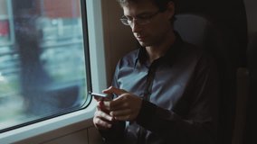 Man Using Phone During Traveling on Train. Shot on RED Cinema Camera in 4K (UHD).