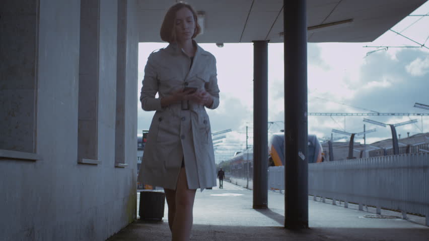 Confident Woman in Trench Walking in Railway Station. Shot on RED Cinema Camera in 4K (UHD).
