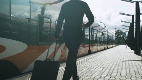 Man with Luggage Chasing Departing Train. Shot on RED Cinema Camera in 4K (UHD).
