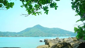 Beautiful and peaceful. rocky tropical beach from the shade of a tree in Kamala. on the island of Phuket in Thailand. Video 4k