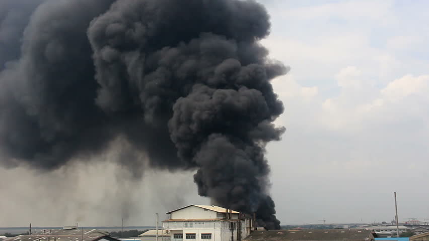 Fire burning and black smoke over a factory. | Shutterstock HD Video #12550394