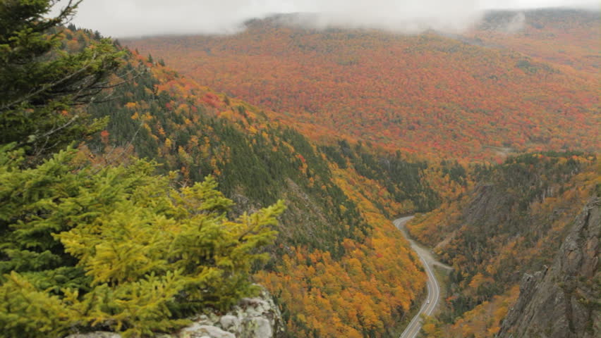 Aerial, locked down view of New Hampshire state highway 26 as it goes through Dixville Notch during peak foliage season.