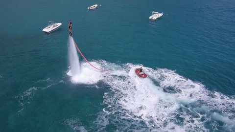 Aerial view on man enjoying water jet pack flyboard at the sea.
