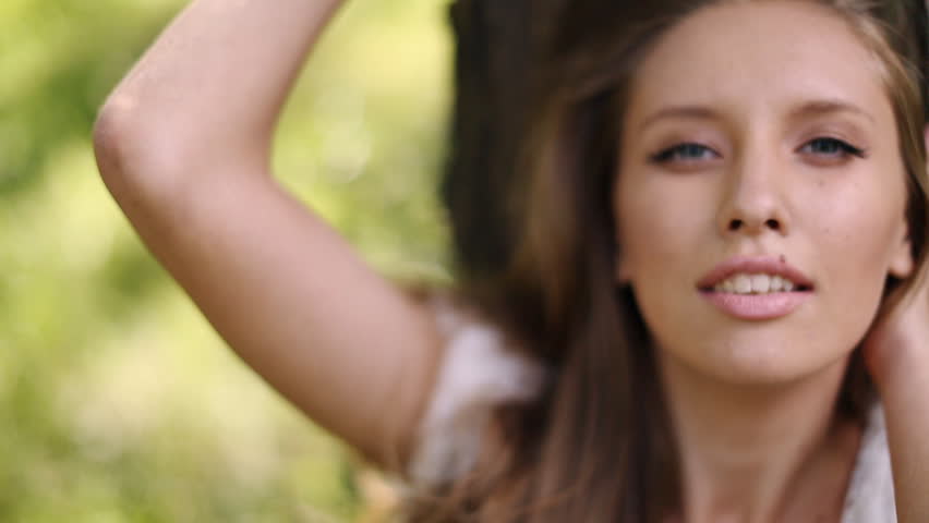 sexy girl in white dress near a tree in the sun
