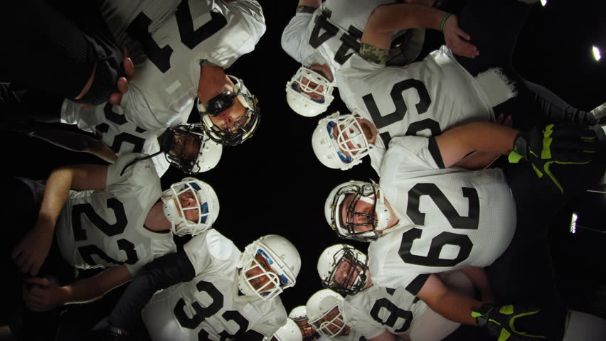 Low angle view looking up at football players inside a huddle