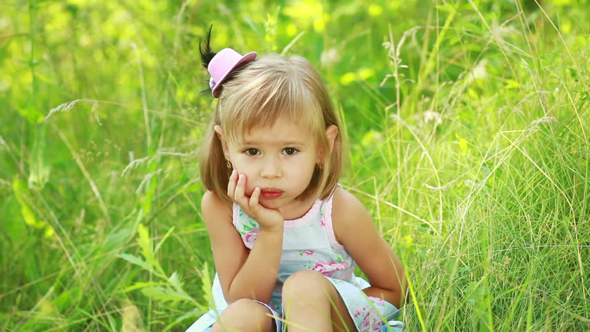 Little girl sitting in the grass 