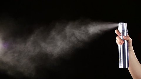 Spray bottle drops for hairstyle on black background, slow motion