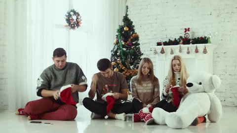 Group of friends wears Santa hats and hugging. Emotional christmas scene