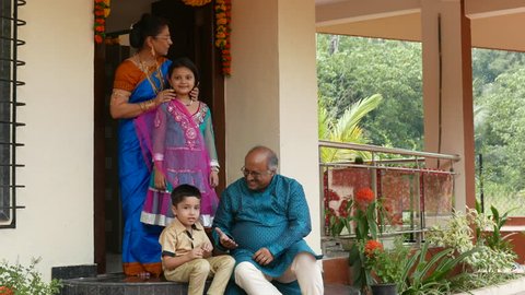 4K video footage of Indian family in traditional outfits celebrating Diwali or deepavali, festival of lights at home. : film stockowy