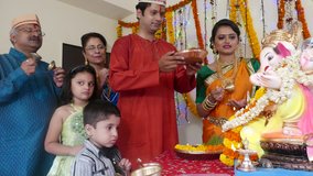 4K video footage of Indian family in traditional outfits celebrating Ganesha festival at home. 