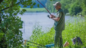 In this video, we can see an old fisherman fishing.It is a beautiful summer day. The wind is slightly blowing. He is then catching a fish. Wide-angle shot.