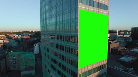 Aerial Orbit Shot of Glass Office Building With Green Screen Mock-up of Billboard in Business District.