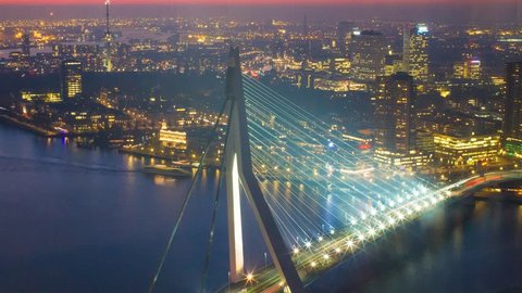 Long exposure static timelapse of the famous erasmus bridge in with the urban skyline of one of europe's biggest harbours in Rotterdam, the Netherlands