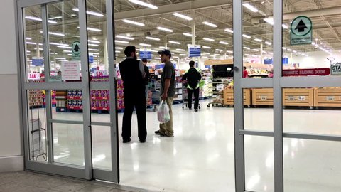 Coquitlam, BC, Canada - November 02, 2015 : People with Shopping Cart Walking Through the Doors at superstore in Coquitlam BC Canada with 4k resolution
