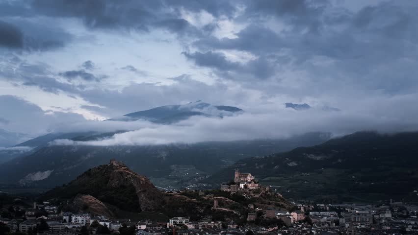 Time lapse of castle on hill during evening and dusk in Sion, Switzerland