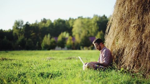 Young man using laptop in the park on a summers day