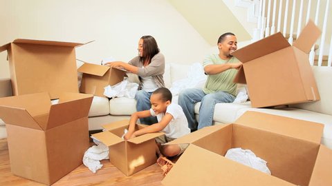 Young african-american family unpacking their belongings after moving to new home