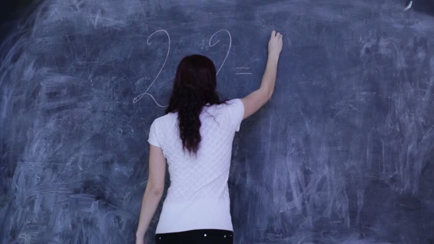 The woman wrote on the blackboard in the classroom mathematical equation