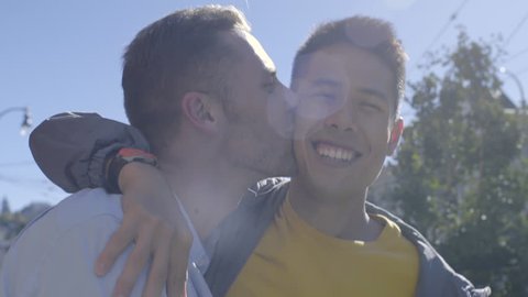 Closeup Of Happy Gay Couple Walking Down The Street In San Francisco, Man Kisses His Boyfriend On Cheek