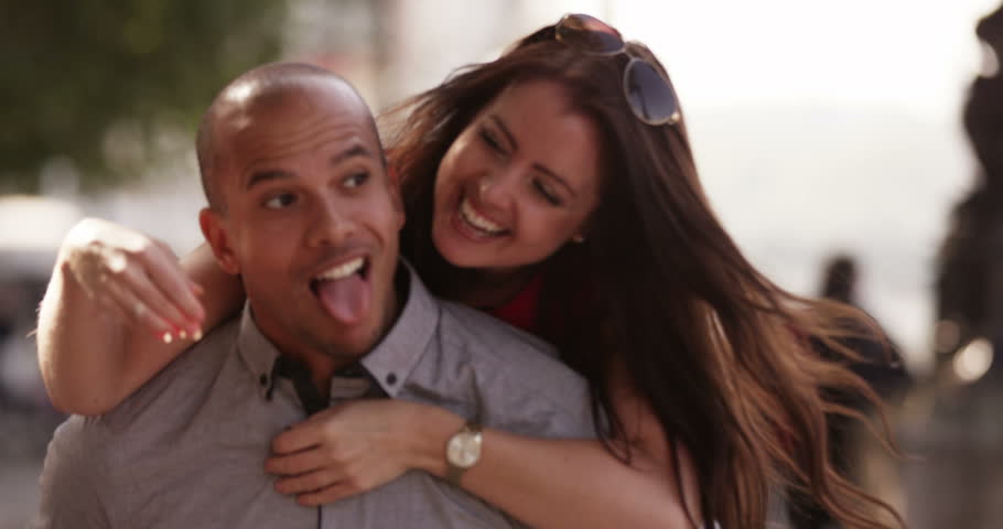 A happy young man giving his girlfriend a piggyback ride outside in the street. Shot on RED Epic. | Shutterstock HD Video #12608435
