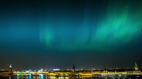 Northern Lights in full display over the bay Riddarfjärden in central Stockholm, Sweden showing the City Hall to the left.