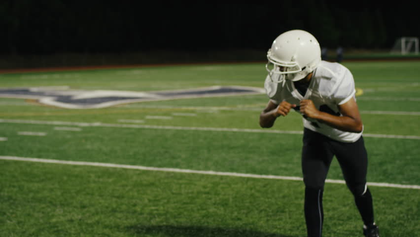 A football player runs down the field and catches the ball and runs for a touchdown Royalty-Free Stock Footage #12617474